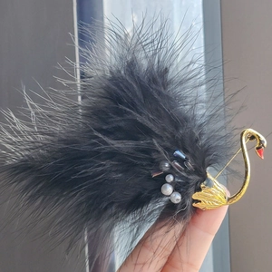 Macro detail of swan brooch featuring black feathers, faux pearls and crystals