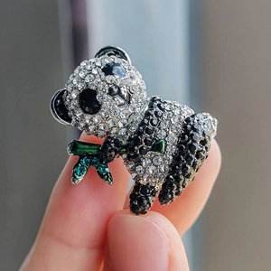 Spilla a forma di panda scintillante con bambù verde e strass mostrata sulla mano