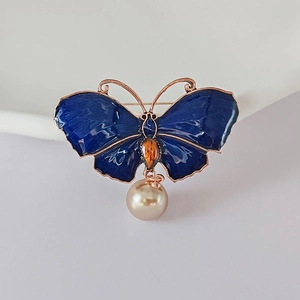 Detail der blauen Emaille-Schmetterlingsbrosche mit Roségoldrand und hängender Perle