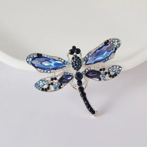 Vista macro di spilla a forma di libellula con cristalli blu e base in metallo argento