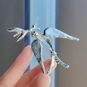 Detailed back view of silver bird brooch showing pin clasp and feather texture