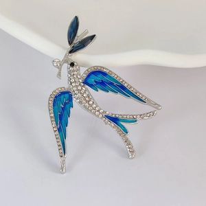 Close-up view of an elegant blue swallow enamel brooch decorated with clear crystals