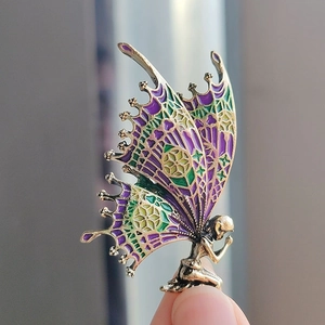Makroaufnahme der handgefertigten Schmetterlingsfee-Brosche mit bunt lasierten Flügeln