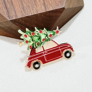 Macro shot of red car brooch with green Christmas tree and rhinestone accents