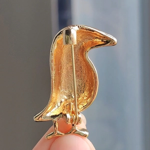 Detailed back view of a golden bird brooch featuring a secure metal pin clasp mechanism
