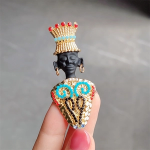 Detailed view of tribal chief brooch with colorful enamel beads and golden crown
