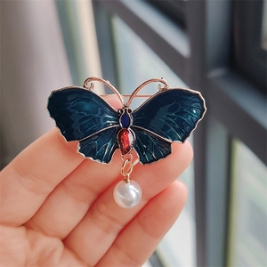 Details der vergoldeten Schmetterlingsbrosche mit blauem Emaille und weißer Perle