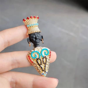 Macro shot of exotic tribal chieftain brooch featuring gold crown and turquoise beads