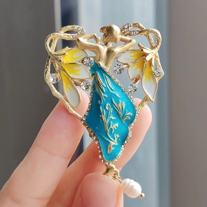 Detail der Vintage-Engelsbrosche mit blauen Emaille-Flügeln und hängender Tropfenperle
