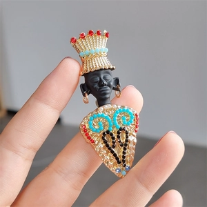Macro detail of vintage tribal chief brooch with colorful crystals and golden crown