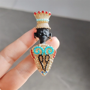 Detail of vintage tribal chief brooch featuring colorful faux gemstones and golden crown