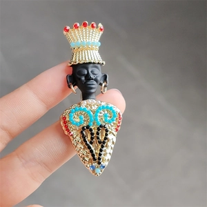 Macro detail of African tribal chief brooch with vintage gold crown and colorful beads