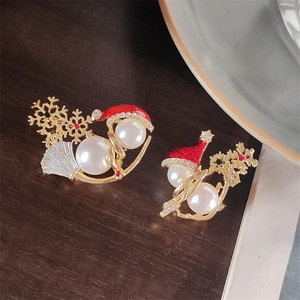 Macro shot of pearl snowman pins with red enamel hats and crystal snowflake charms