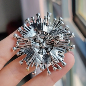 Vintage silver sunburst flower brooch with crystal accents and classic pin clasp back