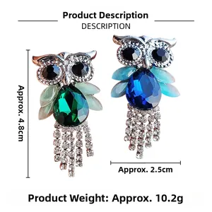 Detail of owl brooches with green and blue crystals and silver rhinestone tassels