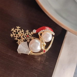 Close-up of a Christmas snowman brooch with pearls, snowflakes and colorful rhinestones