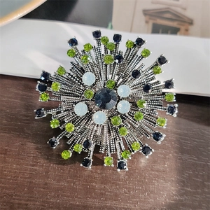 Vintage floral firework brooch with deep blue and green crystals on silver base