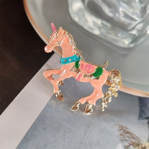 Dettaglio della spilla unicorno rosa carosello con finitura smaltata e strass luminosi