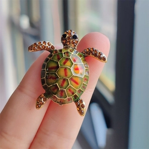 Macro shot of colorful turtle brooch with enamel shell and sparkling brown crystals