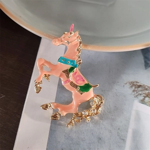 Dettaglio di una spilla a forma di unicorno in smalto con strass e metallo dorato