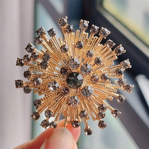 Detailed macro view of vintage golden firework brooch with grey rhinestone inlay