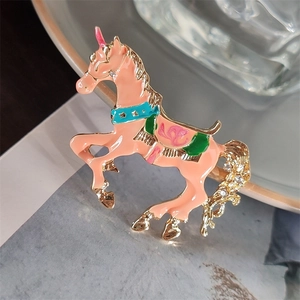 Dettaglio della spilla a unicorno in smalto pastello con cristalli lucidi e placcatura oro
