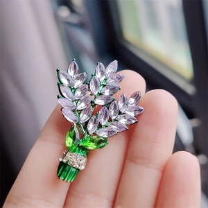 Close-up of lavender crystal flower brooch with purple marquise stones and green enamel leaves
