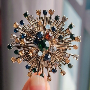 Detail of vintage flower brooch with multicolor rhinestones and antique gold finish