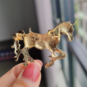 Vista posteriore di una spilla a forma di unicorno dorato con chiusura a spilla di sicurezza