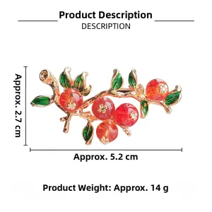 Detailed view of Persimmon branch brooch with red berries and green enamel leaves