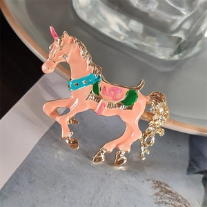 Dettaglio di una spilla unicorno rosa con smalto colorato e piccoli cristalli