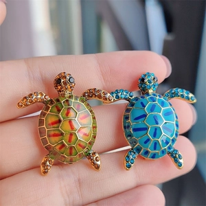 Detailed macro view of colorful enamel turtle brooches with sparkling crystal inlay