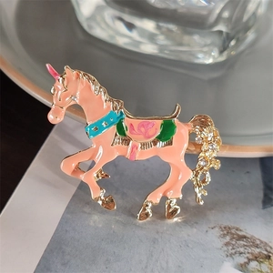 Dettaglio macro della spilla unicorno in smalto rosa con accenti di cristallo lucido