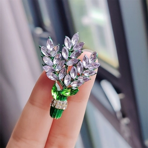 Detail of lavender crystal flower brooch with purple rhinestones held in hand