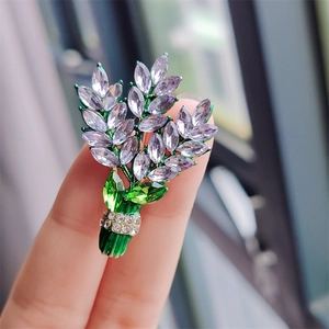 Macro detail of lavender crystal flower bouquet brooch with purple and green rhinestones