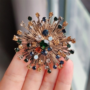 Macro detail of vintage floral brooch with multicolored rhinestones and antique gold finish