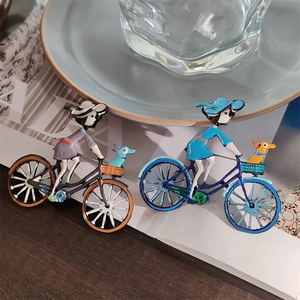 Broche en émail dessin animé montrant une fille à vélo avec un chien aux couleurs vives