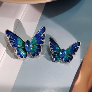 Detail van vlinderbroche met blauwe emaille vleugels en kristallen midden