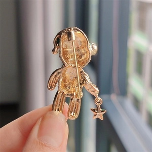 Makroaufnahme der goldenen Teddybär-Brosche Rückseite mit Sicherheitsnadel und Textur