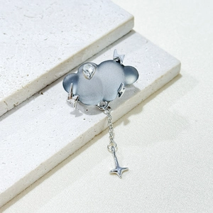 Creative cloud brooch with crystal raindrop and lightning detail on a textured stone base