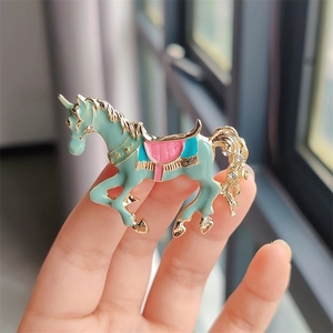 Dettaglio di spilla unicorno in smalto colorato con rilievo stellato e strass lucenti