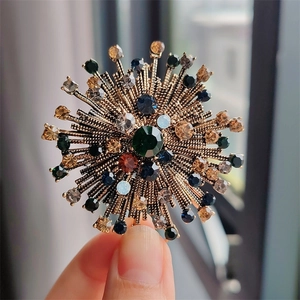 Close-up of vintage floral brooch with multicolored rhinestones on gold metal base