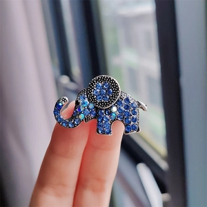 Detailed macro view showing blue rhinestones on the vintage silver elephant brooch