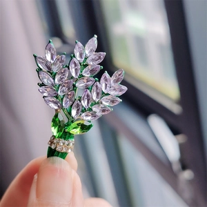 Close-up of lavender crystal wheat brooch with green enamel leaves and tiny diamonds