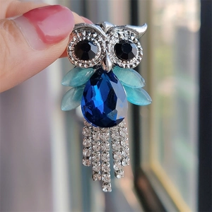 Elegant owl brooch featuring blue crystal wings and sparkling tassel fringe detail
