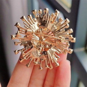 Detail of vintage flower brooch back featuring golden alloy texture and pin clasp