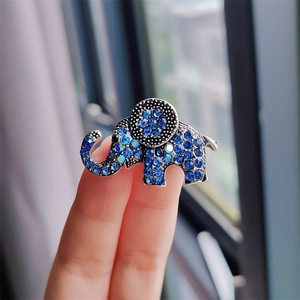 Detailed macro of a silver-toned elephant brooch with blue and colorful rhinestones
