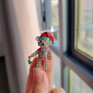Detailansicht einer funkelnden Teddybär-Brosche mit Strass und Weihnachtsmütze