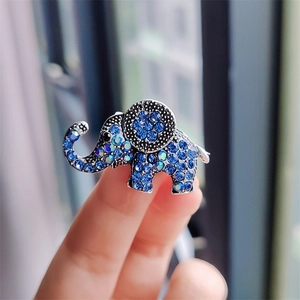 Detailed macro view of an elephant brooch with dark blue rhinestones held in hand