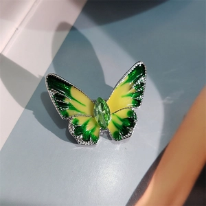 Detail van vlinderbroche met groene emaille vleugels en marquise kristal in het midden